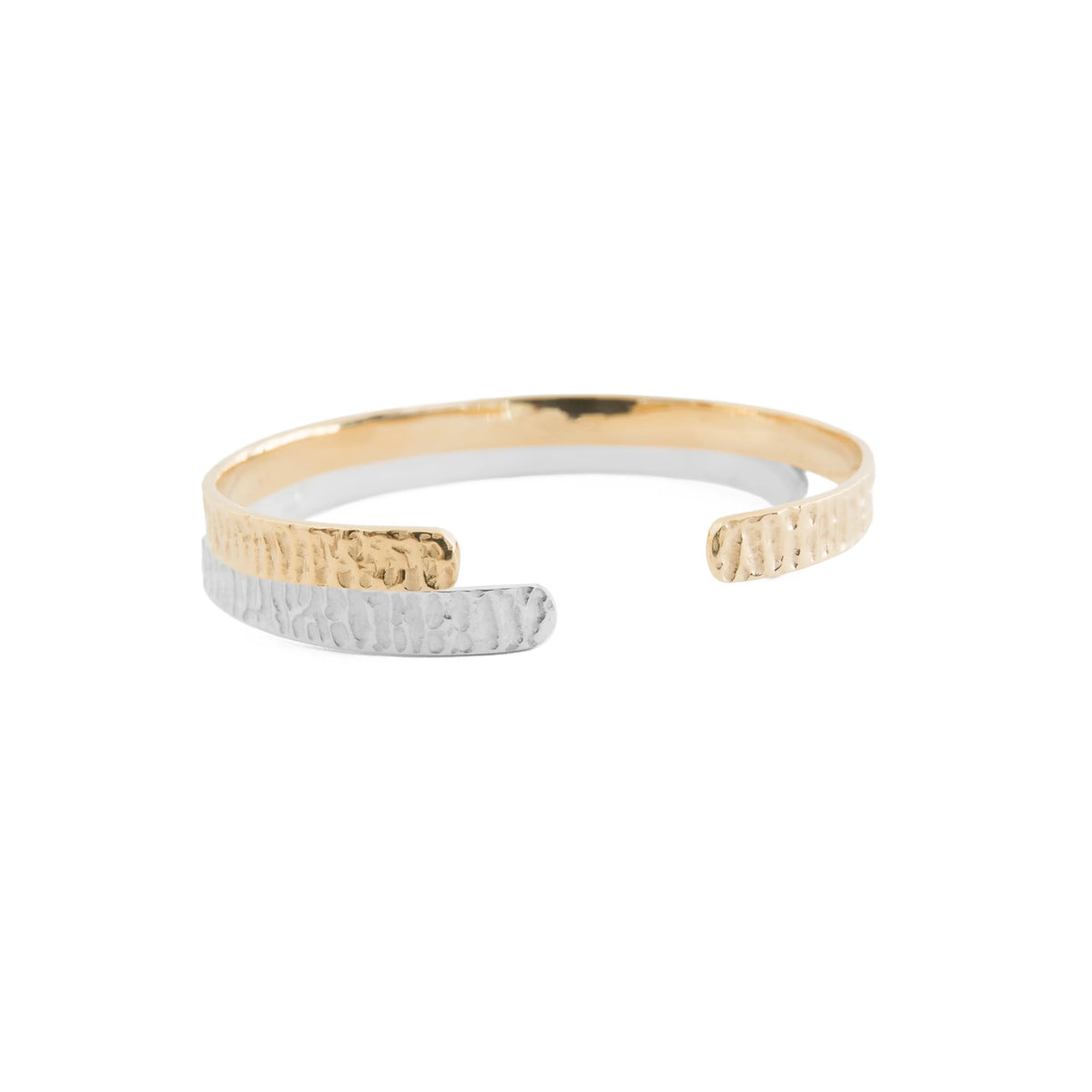One silver and one gold foundation textured bangles resting on top of each other on a white background