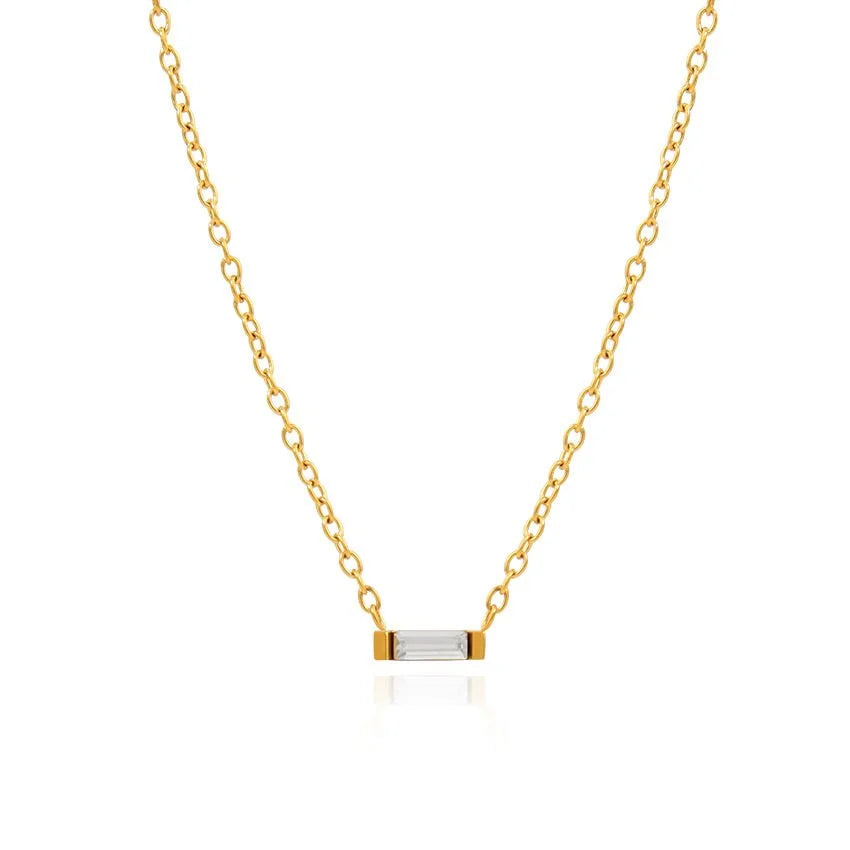 A delicate gold chain necklace with a small horizontal bar pendant featuring a clear rectangular baguette cubic zirconia crystal, set against a solid white background.
