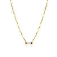 A delicate gold chain necklace with a small horizontal bar pendant featuring a clear rectangular baguette cubic zirconia crystal, set against a solid white background.