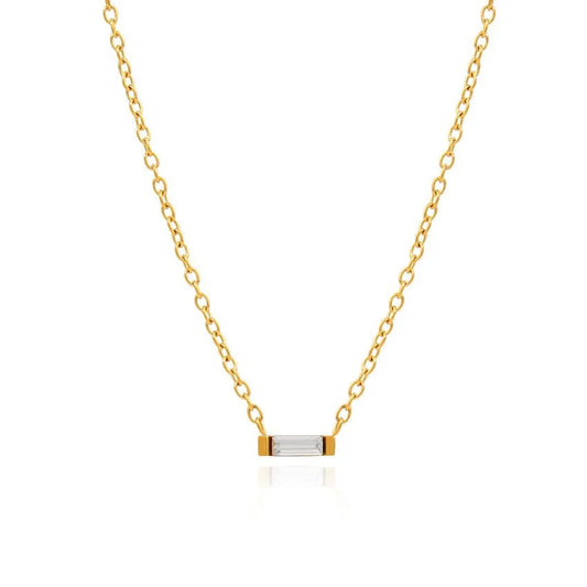 A delicate gold chain necklace with a small horizontal bar pendant featuring a clear rectangular baguette cubic zirconia crystal, set against a solid white background.