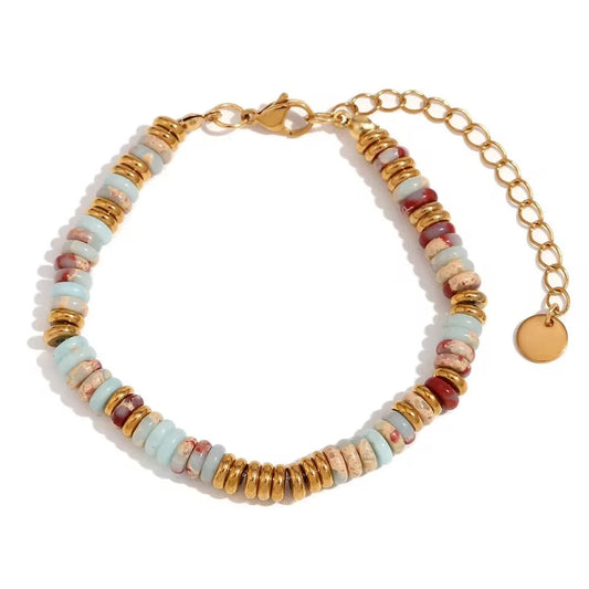Gemstone beaded bracelet with soft blues, turquoise, gold and burgundy  with gold chain on a white background