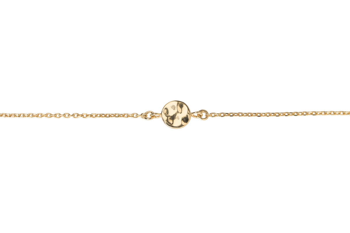 Close up of slightly melted disk design on a gold chain 