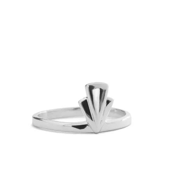 A silver ring with a sculptural, fan-like geometric top, photographed on a seamless white background.