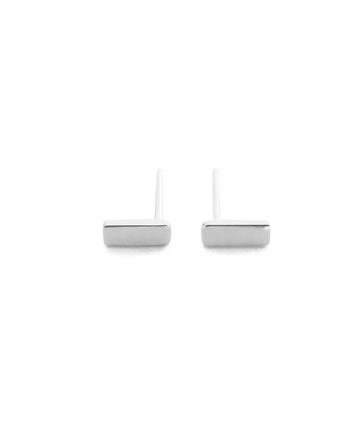 A pair of minimalist silver stud earrings with flat rectangular bar studs and straight posts, shown on a solid white background.