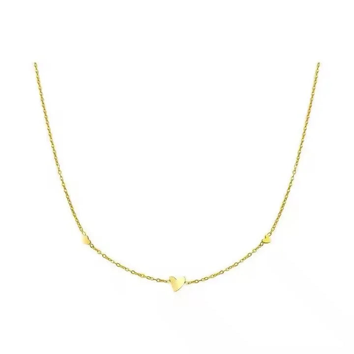 A delicate yellow gold chain necklace featuring a small, polished heart pendant at the center and one at either side, displayed against a solid white background.