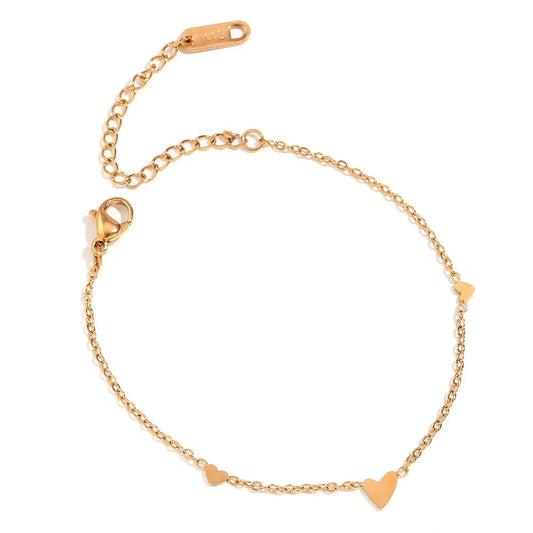 A delicate gold chain bracelet with three small heart charms, displayed on a clean white background.
