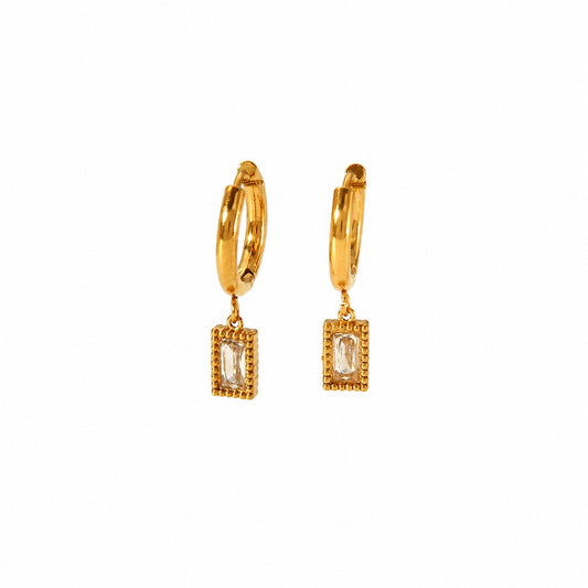 A pair of gold Glister huggie hoop earrings with rectangular bezel-set cubic zirconia baguette crystals, shown on a plain white background.