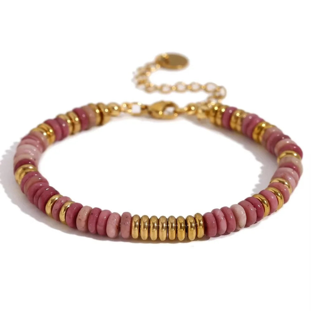 A beaded bracelet featuring pink gemstone beads with gold beads and a gold clasp, shown on a white background.