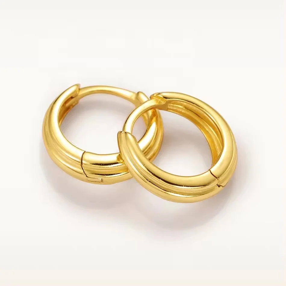 A pair of shiny gold Stack huggie hoop earrings on a clean white background.