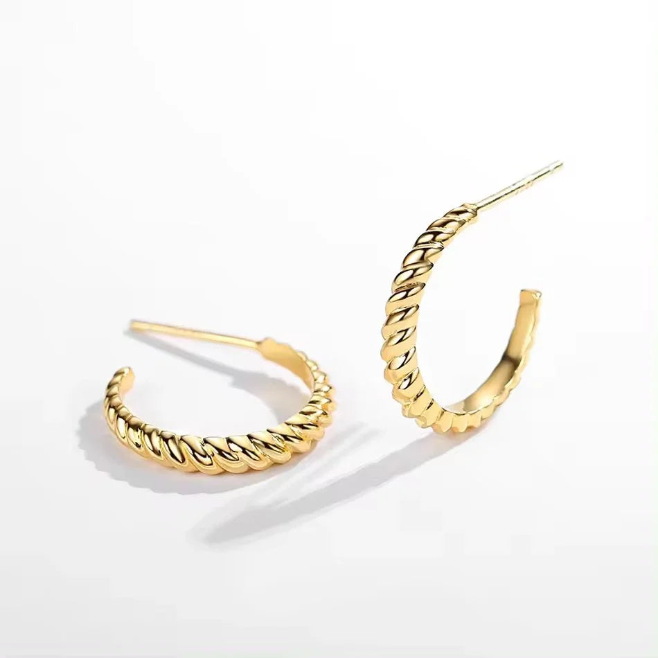 A pair of gold-toned twisted hoop earrings with post-back closures, displayed on a clean white background.