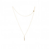 A delicate gold layered necklace featuring a fine chain with a small vertical bar pendant and a secondary chain with a small disk detail, displayed on a clean white background.