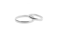 Two slim silver ring bands interlocking on a plain white background.