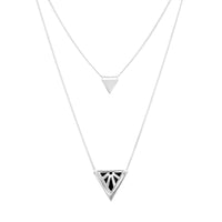 A silver geometric necklace featuring two layered triangle pendants, one small plain triangle and one larger triangle with a Rise stylised sun cutout pattern, on a solid white background.