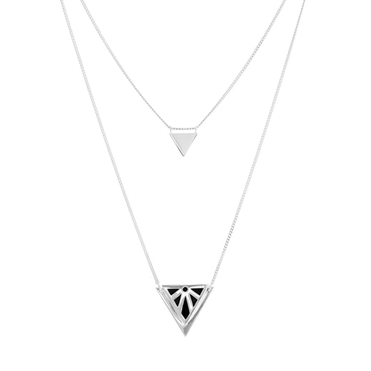 A silver geometric necklace featuring two layered triangle pendants, one small plain triangle and one larger triangle with a Rise stylised sun cutout pattern, on a solid white background.