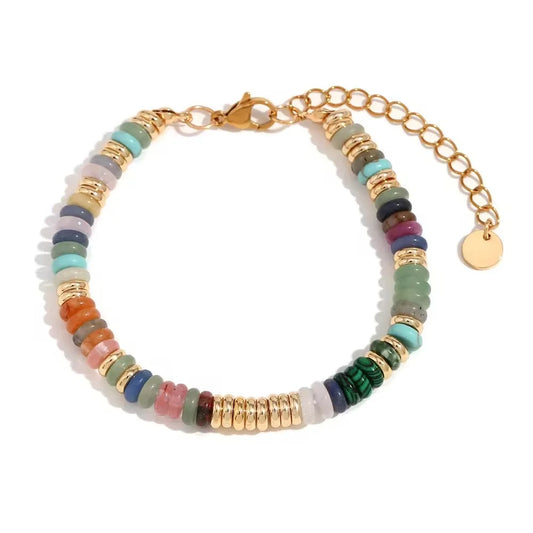 Multicolored gemstone bracelet with gold beads on a gold chain on a white background