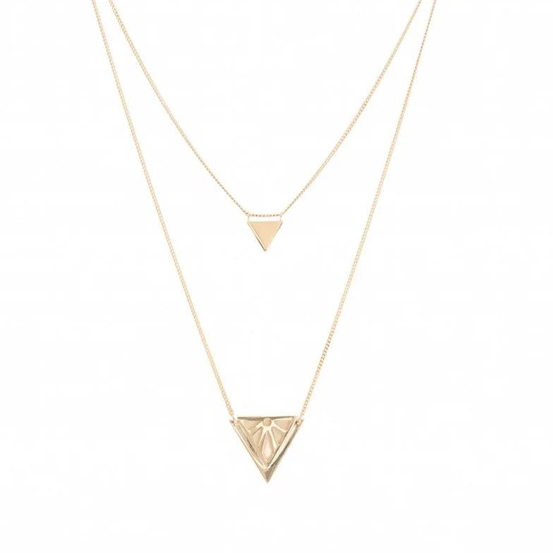 A double-layered gold necklace set featuring a delicate chain with a small triangle pendant and a longer chain with a larger, faceted triangle pendant, displayed on a clean white background.